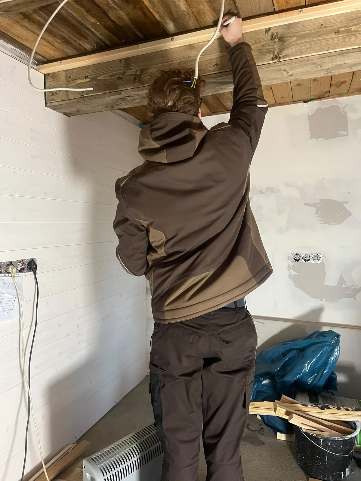 Moritz beim Ausbau an den freigelegten Deckenbalken der Forest Lodge I